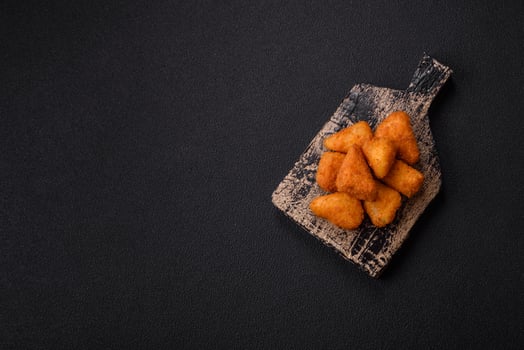 Breaded camembert or brie cheese baked in the form of nuggets with salt and spices photo