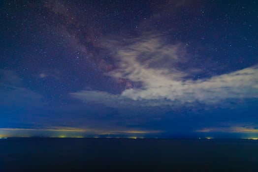 starry night sky over large mountain lake at night photo