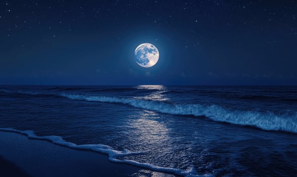 Bright moon casting a long reflection on the ocean photo