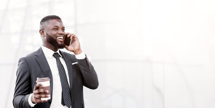 Smiling African American Businessman Chatting On Phone Having Coffee Outdoors In City. Always In Touch Concept. Empty Space photo