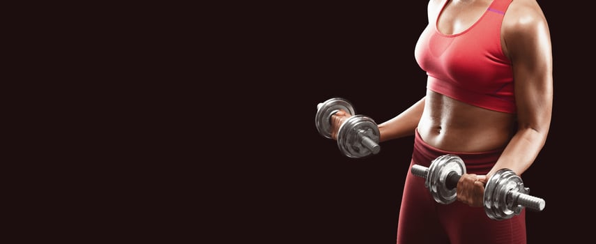 Cropped of athletic afro woman holding barbells over black background photo