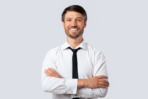 Cheerful Business Guy Smiling At Camera Crossing Hands Standing Over White Studio Background. Isolated, Empty Space photo