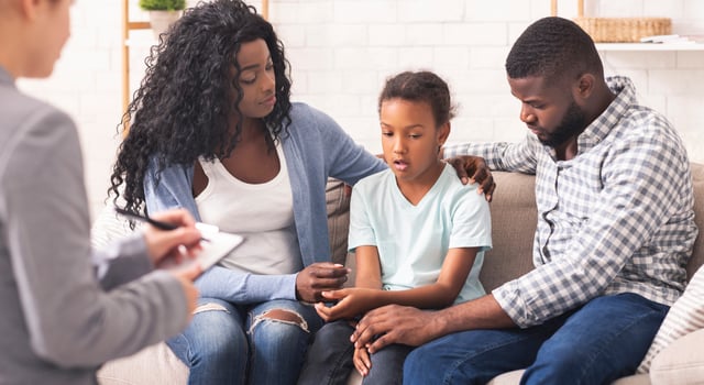Bipolar Disorder In Children Concept. Little african american girl and her parents at reception of psychologist, kid sharing her feelings with doctor photo