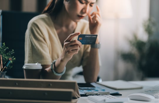 Unhappy and dissatisfied young Asian female office employee contacts a credit card call-center service to inform them of the problems. photo