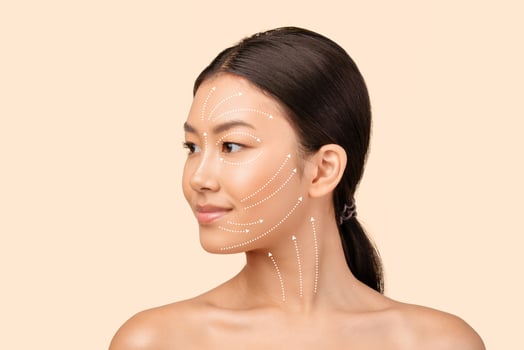 Asian Woman's Face Portrait With Lifting Arrows Showing Antiaging Facial Skincare Treatment, Headshot On White Studio Background, Looking Aside. Ageless Beauty And Plastic Surgery Concept photo