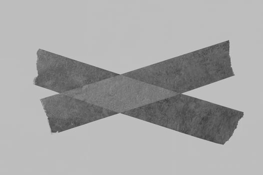 Black Adhesive Tape on Gray Background with Torn Edges photo