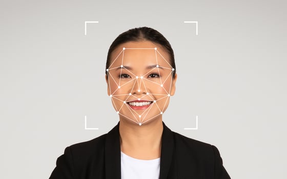 Chinese woman is smiling as facial recognition technology is displayed on her face in a professional studio environment. photo