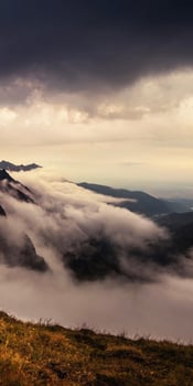 A view of the mountains and clouds from a hill photo