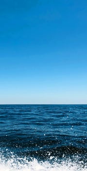 A boat is sailing across the ocean with a blue sky photo