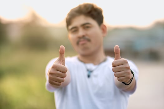 a man standing with his thumbs up. The man acted like someone was giving a compliment to something. set in nature on a sunny afternoon. photo