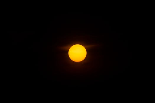 Big sun on dark sunset sky with dark clouds. photo