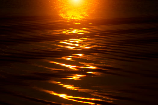 Defocus Water surface images reflect the sunlight at the lake in golden time photo