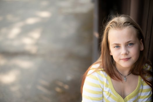 Portrait of little girl face with blue eyes looking at camera photo