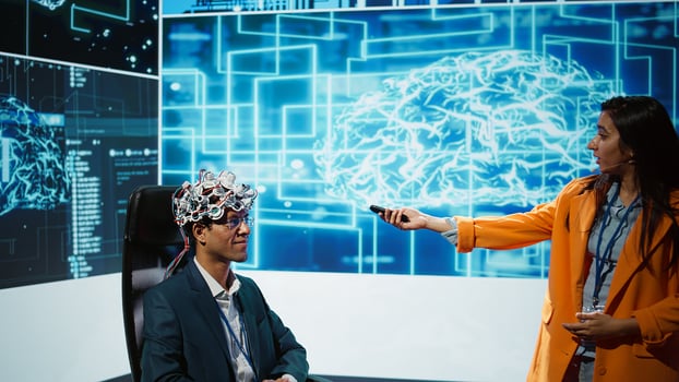 Presenter talking at AI neuroscience forum bringing together IT professionals, showing EEH headset demonstration of latest developments in artificial intelligence mind transfer, camera B photo
