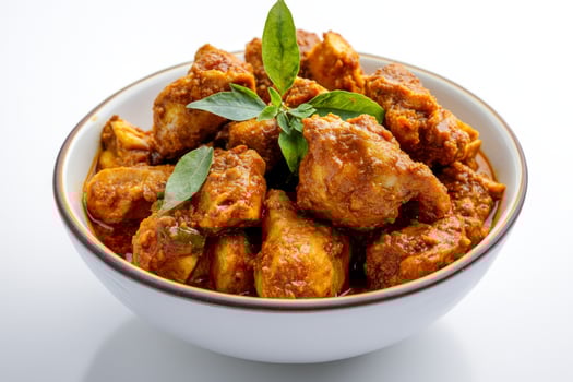 A bowl of chicken curry with a leafy green leaf photo
