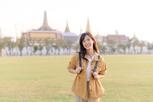 A Traveler Asian woman in her 30s exploring Wat Pra Kaew. From stunning architecture to friendly locals, she cherishes every moment, capturing it all in her heart and camera for years to come. photo