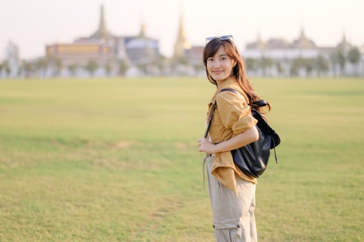 A Traveler Asian woman in her 30s exploring Wat Pra Kaew. From stunning architecture to friendly locals, she cherishes every moment, capturing it all in her heart and camera for years to come. photo