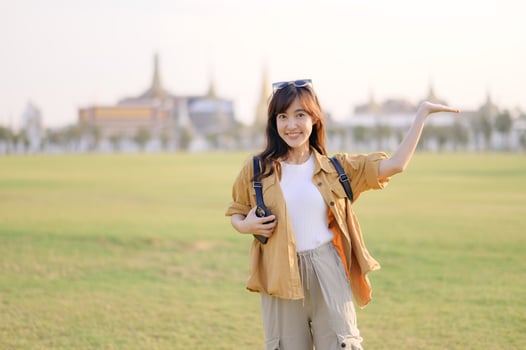 A Traveler Asian woman in her 30s exploring Wat Pra Kaew. From stunning architecture to friendly locals, she cherishes every moment, capturing it all in her heart and camera for years to come. photo