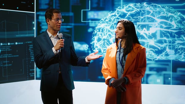 Cheerful host and expert guest talking at AI summit bringing together tech company workers, exploring latest innovations and discoveries in artificial intelligence industry, camera A photo