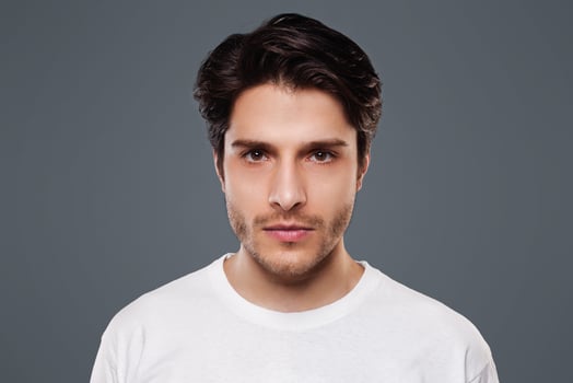 Confident man. Young millennial guy seriously looking at camera, grey background photo