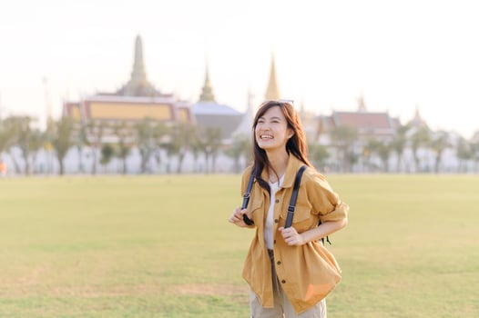 A Traveler Asian woman in her 30s exploring Wat Pra Kaew. From stunning architecture to friendly locals, she cherishes every moment, capturing it all in her heart and camera for years to come. photo