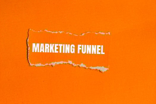 Marketing funnel message written on ripped torn orange paper with orange background. Conceptual marketing funnel symbol. Copy space. photo