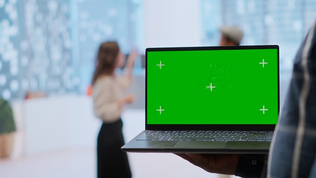 Realtors and client evaluating blueprints next to green screen display, working on new high class office space layout development. Businesswoman sharing her interior design vision. Camera B. photo