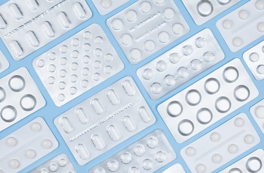 Medicine pills blisters on a blue. Symmetry medical background. Stock photo. photo