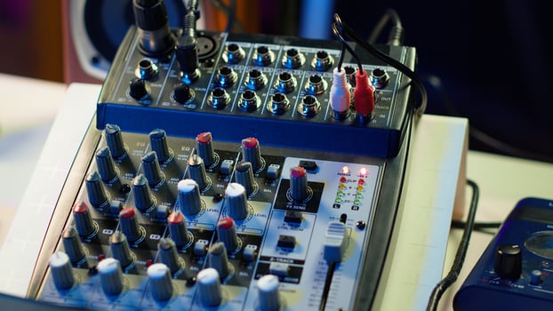 Empty home studio desk with motorized faders and pre amp knobs used with a mixing console and equalizer to produce music. Modern space with amplifier and devices for mix and master. photo