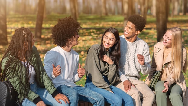 Carefree multiethnic teenagers having good time at public park photo