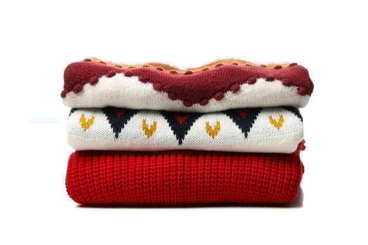 Pile of sweaters isolated on white background photo