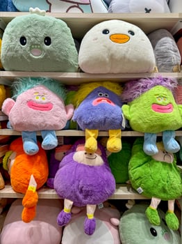 Soft toys on the shelves in a children's store for sale photo
