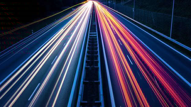 A closeup of the highway shows the intricate patterns created by the light streaks of vehicles ping by in a long exposure shot photo