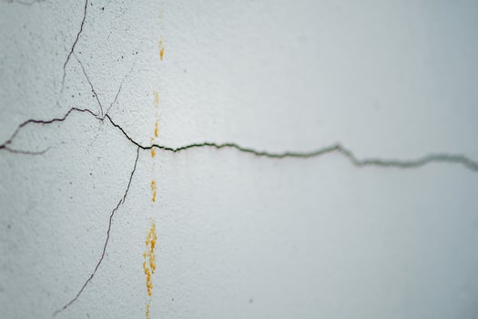 A crack in the wall with a yellow paint photo