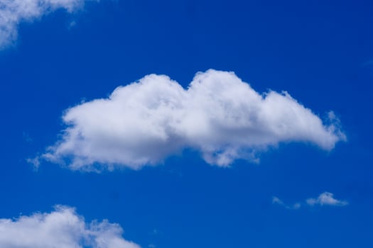 Fluffy White Cloud Against a Vibrant Blue Sky on a Clear Day photo