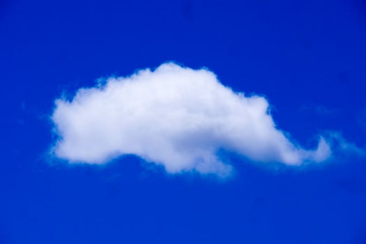 Fluffy White Cloud Against a Vibrant Blue Sky on a Clear Day photo