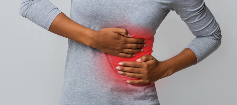 Black girl holding her side, suffering from acute liver pain, cropped photo