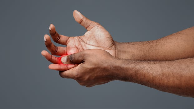 Cropped of man suffering from pain in hand and massaging his painful finger, white background photo