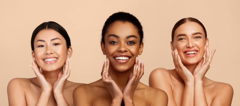 Skincare Concept. Three Diverse Women Touching Face Caring For Perfect Skin Standing On Gray Background, Smiling To Camera photo
