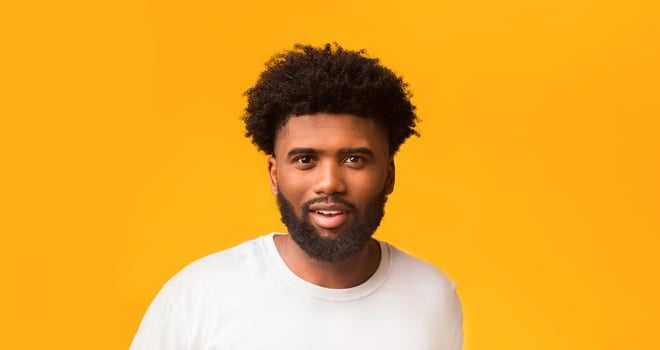 Portrait of handsome african american guy over orange background photo