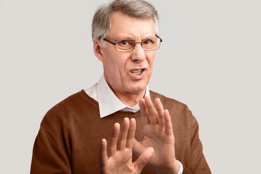 Disgust. Disgusted Senior Man Gesturing No Disapproving Something Posing On Gray Background. Studio Shot photo