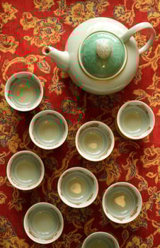 A table with several tea cups and a teapot photo