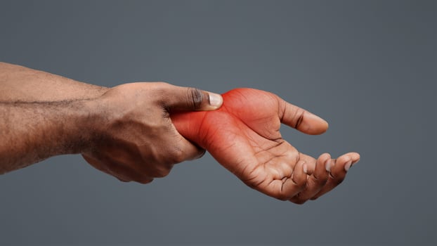 Carpal tunnel pain. Black guy massaging painful wrist, close up photo