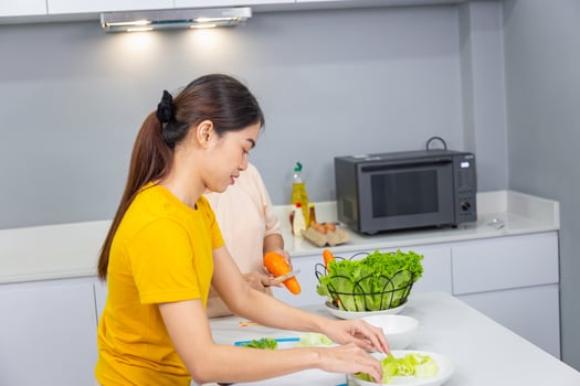 Asian middle aged daughter and senior mother cooking together at kitchen photo