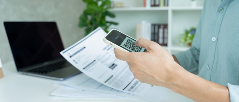 business man use phone to scan barcode or QR codes to pay credit card bill after receiving document invoice online. payment, receive, paying electricity, digital payments without money, technology photo