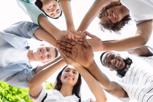 Friends Unity. Low Angle Portrait Of Happy Teenage People Stacking Hands Together And Smiling At Camera, Showing Teamwork And Cooperation photo