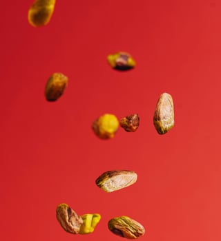 Pistachios falling down on red background photo