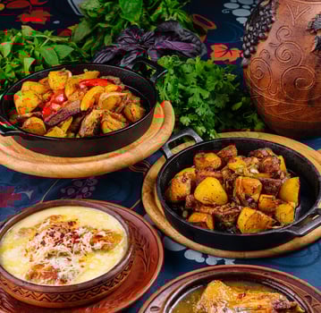 Georgian cuisine dishes with vegetables and herbs on blue tablecloth photo