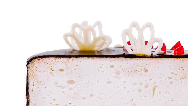 Delicious layered bird's milk cake is being cut with a knife on a white background photo