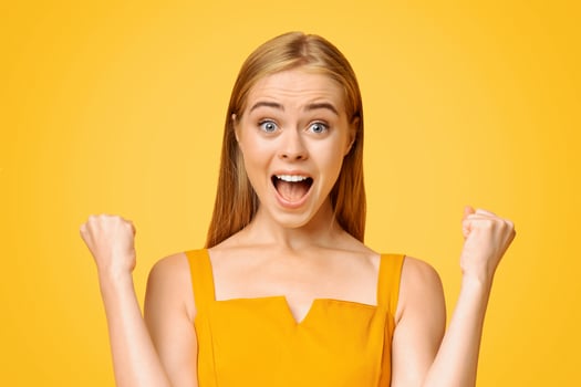 Big Win. Overjoyed Teen Girl Emotionally Rejoicing Success With Raised Fists, Standing Over Yellow Background, Looking At Camera photo